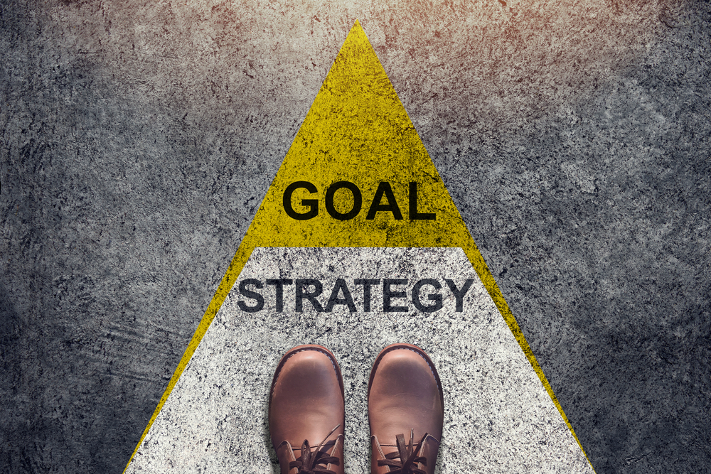 "Goal strategy" sign on the ground and shoes.